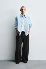 Jeans de denim de algodón, color azul oscuro con efecto lavado. Presentan un corte muy holgado (baggy fit) en toda la pierna y tiro medio. Tienen cinco bolsillos y cierre frontal con cremallera y botón.