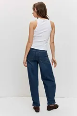 Musculosa blanca de ajuste ceñido con cuello redondo y detalle de apliques metálicos a lo largo de la parte frontal.