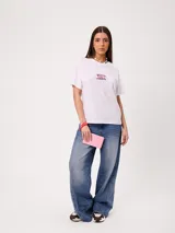 Remera blanca con estampado colorido en la espalda con motivos marinos, cangrejos y caracoles, de manga corta y ajuste holgado.