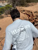 Remera celeste de corte recto con estampado en la espalda que incluye el texto "Itta Stars Tour" y una lista de ciudades: Ibiza, Madrid, Andorra, Barcelona y Formentera.