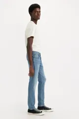 Jean de corte slim taper en color azul medio, de tiro medio con diseño de cinco bolsillos y efecto ligeramente deslavado.