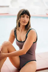 Traje de baño entero color visón con bordes de terciopelo verde inglés y detalle de óvalo en la espalda.