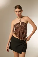 Top de cuello halter con diseño fruncido y caída holgada, confeccionado en tela con estampado de puntos.