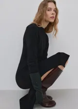 Vestido midi negro de manga larga, con escote redondo, lazo ajustable en la cintura y tajo lateral.