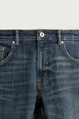 Jeans skinny fit de color azul, con efecto lavado y detalles de roturas en las piernas. Diseño de cinco bolsillos, tiro medio y cierre frontal con cremallera y botón.
