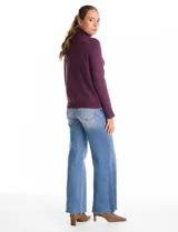 Polera de cuello alto confeccionada en tejido de punto fino, con mangas largas y detalle de tajo en los puños.