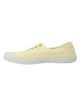 Zapatillas de lona color amarillo claro, con suela y puntera de goma blanca, ojalillos metálicos y diseño ligero sin cordones.