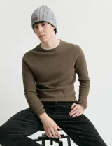 Sweater de punto con textura waffle, color negro, de corte clásico con cuello redondo y mangas largas con puños ajustados.