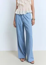 Pantalon wide leg de denim suave, color azul claro, con tiro medio, cierre frontal de cremallera y botón, detalle de pinzas y bolsillos laterales.