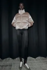 Anorak acolchado de efecto brillante con tejido cortavientos y repelente al agua. Presenta cuello subido, cierre frontal con cremallera, bolsillos delanteros con forro polar y cierre de cremallera, y mangas largas con puños elásticos. El bajo es ajustable con cordones elásticos laterales.