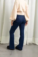 Jean de corte flare oxford, color azul oscuro, con tiro alto y cierre frontal con botón metálico.