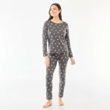 Pijama de dos piezas compuesto por una remera de manga larga con cuello redondo y un pantalón largo de corte recto, ambos confeccionados en tejido de punto gris con estampado de corazones blancos.