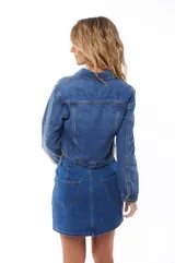 Campera de jean corta color azul con cuello clásico, cierre frontal con botones y mangas largas.