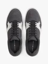 Zapatillas de tenis Tommy Hilfiger de corte bajo, confeccionadas en ante color gris con paneles en contraste de color blanco. Presentan cierre con cordones, suela de goma blanca y logo de la marca grabado en el lateral y el talón.