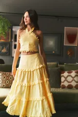 Falda larga de lino color amarillo claro con múltiples capas de volados suaves que aportan fluidez.