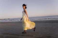 Sandalias bajas de cuero color marrón, con tiras finas para atar alrededor del tobillo.