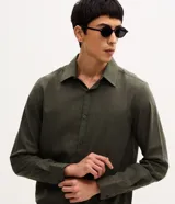 Camisa de manga larga con cuello inglés y cierre frontal de botones, confeccionada en tricolina de algodón color beige.