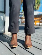 Pantalón de corte recto y tiro alto, confeccionado en tela firme con elasticidad. Presenta un diseño clásico con dobladillo en el ruedo y cierre frontal.