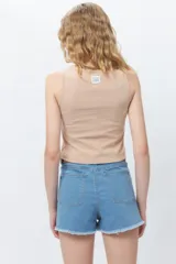 Musculosa corta negra sin mangas, de corte asimétrico frontal y ceñida al cuerpo.