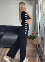 Conjunto negro con pequeños lunares dorados, compuesto por una remera de mangas cortas y un pantalón palazzo con cintura elastizada.