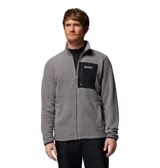 Campera polar de textura suave y cálida, con cierre frontal completo y cuello alto. Presenta un bolsillo en el pecho con cierre y revestimiento de contraste, además de bolsillos laterales. El diseño incluye puños y dobladillo con ribete elástico para mayor protección.