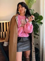 Sweater tejido de punto en color rosado, con diseño de bota estilo western en el frente y detalles de estrellas pequeñas en color rojo. Presenta cuello redondo, mangas largas abullonadas y puños acanalados.