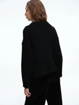 Buzo de textura peluda con escote en V y cuello tipo polo. Presenta una silueta holgada de manga larga con puños y ruedo acanalados.