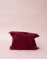 Cartera estilo hobo de gamuza color bordó, con flecos laterales y asa ancha decorada con tachas metálicas plateadas.