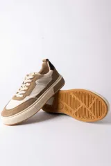 Championes urbanos de diseño moderno, combinando paneles de cuero texturizado en tono tostado y cuero liso en color crema. Presenta una suela de plataforma robusta en tono crema con un detalle en bloque tostado en el talón y un contrafuerte oscuro.
