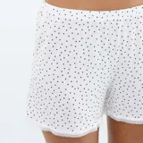 Conjunto de pijama de dos piezas blanco con estampado de lunares negros, compuesto por una musculosa de tirantes finos con detalles de encaje y un short a juego.