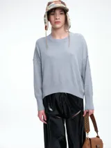 Sweater de punto color negro, con cuello redondo, hombros caídos y terminaciones acanaladas en puños y ruedo. Presenta un diseño de calce relajado y tejido suave.