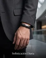 Pulsera de diseño masculino compuesta por una banda de cuero sintético trenzado y una placa central de acero inoxidable con detalles de remaches.