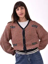 Saco tejido de punto grueso, color negro, con cuello en V y botones frontales. Presenta detalles de punto en contraste en los bolsillos y puños.