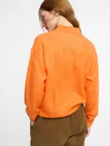 Sweater de punto de cachemira color turquesa con cuello polo y cierre frontal de tres botones. Presenta una textura suave tipo pelo, manga larga y terminaciones acanaladas en puños y ruedo.