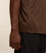 Remera deportiva de hombre con tecnología Dry, cuello redondo y mangas cortas. Presenta un diseño con estampa sutil tipo heat print y detalles de líneas en los hombros.