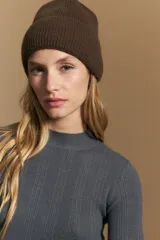 Polera de punto acanalado color gris, con cuello alto y mangas largas, de calce ajustado al cuerpo.