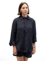 Camisa de lino de manga larga con cuello clásico y cierre frontal de botones. Presenta un corte relajado y un acabado en color azul marino.
