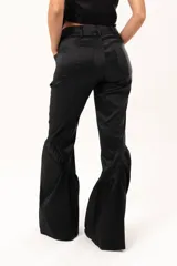 Pantalón de tiro medio con silueta oxford, ajustado en la parte superior y con gran volumen en el bajo. Presenta bolsillos laterales, cierre frontal con cremallera y un detalle fruncido a la altura de la rodilla que aporta movimiento y volumen.