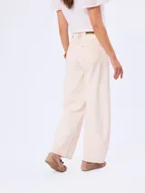 Jean de corte barrel color beige, de tiro medio y diseño amplio en las piernas con costuras pespunteadas a contratono.