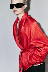 Cazadora corta de Zara color rojo, con cuello smoking, manga larga y cinturón ajustable del mismo tejido.