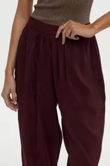 Pantalón babucha bordó con elástico en la cintura trasera y bolsillos laterales, de corte amplio y fluido.