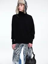 Sweater de cuello polera con diseño de hombros caídos y calce holgado. Presenta puños y ruedo con terminaciones acanaladas, confeccionado en un tejido suave y ligero.