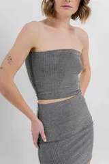 Top strapless confeccionado en tejido elástico con apliques de strass que aportan un efecto brillante tipo glitter. Silueta al cuerpo, calce cómodo y sin cierre.