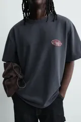 Remera de algodón con efecto lavado, corte relajado, cuello redondo y manga corta. Presenta un gráfico estampado en el pecho con la inscripción Posty Co.