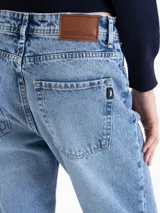 Pantalón de jean recto de tiro medio en color azul lavado. Presenta un diseño clásico de cinco bolsillos, con cierre frontal y botón metálico.