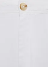Pantalón de lino color blanco, de corte recto y tiro medio. Cuenta con trabillas para cinturón, dos bolsillos laterales y cierre oculto con botón, gancho y cremallera.