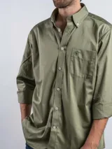 Camisa de manga larga color verde oliva, confeccionada en algodón, con cuello abotonado, cierre frontal de botones y bolsillo en el pecho con logo bordado.