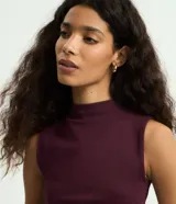Musculosa básica de canalé color beige, de cuello alto y diseño sin mangas con calce al cuerpo.