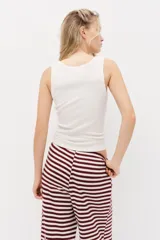 Pantalón de punto suave, de piernas amplias y corte holgado, con diseño a rayas horizontales en color bordó y blanco. Cuenta con cintura elástica y cordón ajustable.