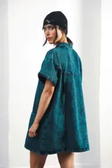 Vestido corto marrón con efecto desgastado, cuello camisero, cierre frontal con cremallera metálica, mangas cortas, dos bolsillos frontales y bordados de soles en el canesú delantero y trasero.